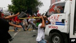 Manifestantes atacaron un forgón policial en Manila después que los atropellara durante una protesta frente a la embajada de Estados Unidos, el miércoles, 19 de octubre, de 2019.