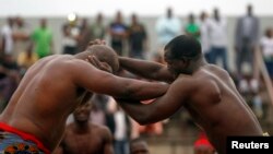 Le Nigérien Lamine Medeba combat le Sénégal Pape Sene lors d'une compétition de lutte, à Abidjan, en Côte d'Ivoire, le 17 août 2014.