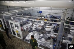 FILE - Minors lie inside a pod at the Donna Department of Homeland Security holding facility, the main detention center for unaccompanied children in the Rio Grande Valley, in Donna, Texas, March 30, 2021.