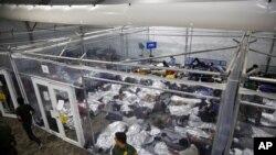 Young minors lie inside a pod at the Donna Department of Homeland Security holding facility, the main detention center for unaccompanied children in the Rio Grande Valley, in Donna, Texas, March 30, 2021. 