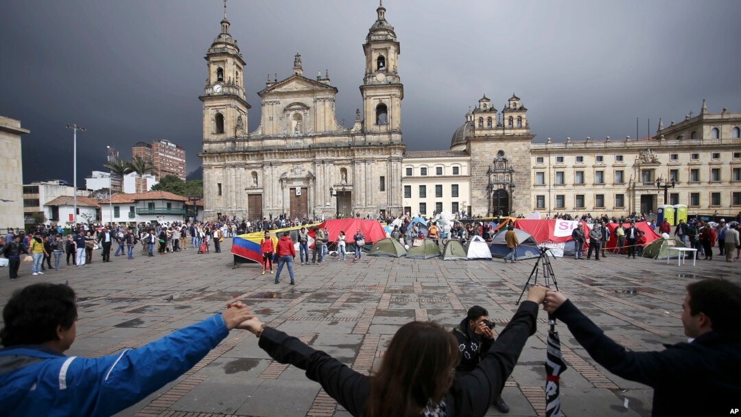 Para demonstran bergandengan tangan untuk menunjukkan dukungan terhadap persetujuan perdamaian antara pemerintah Kolombia dan kelompok pemberontak FARC di alun-alun utama Bogota, 8 Oktober 2016.