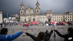 Para demonstran bergandengan tangan untuk menunjukkan dukungan terhadap persetujuan perdamaian antara pemerintah Kolombia dan kelompok pemberontak FARC di alun-alun utama Bogota, 8 Oktober 2016.