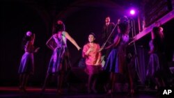 This undated theater image released by The Public Theater shows Ruthie Ann Miles, center, during a performance of "Here Lies Love," in New York. 