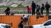 TOPSHOT - US Customs and Border Protection officers take an immigrant child from her mother after they crossed the border from Mexico in Eagle Pass, Texas on December 22, 2023.