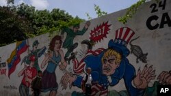 Niños pasan frente a un mural que representa al Tío Sam en Caracas, Venezuela, el miércoles 18 de mayo de 2022.