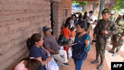 Esta fotografía publicada por la Presidencia de Guatemala muestra a un trabajador social hablando con ciudadanos mexicanos en un refugio temporal en una escuela en Nueva Reforma, Huehuetenango, Guatemala, el 27 de julio de 2024.