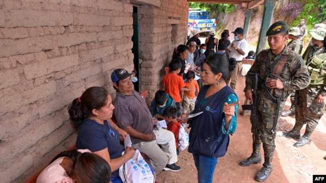 Esta fotografía publicada por la Presidencia de Guatemala muestra a un trabajador social hablando con ciudadanos mexicanos en un refugio temporal en una escuela en Nueva Reforma, Huehuetenango, Guatemala, el 27 de julio de 2024.