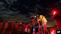 A student looks up at the moon through a telescope, during a visit by The Traveling Telescope to show students the science of astronomy, at St Andrew's School near Molo in Kenya's Rift Valley, Feb. 3, 2017.