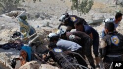This photo provided by the Syrian Civil Defense White Helmets, which has been authenticated based on its contents and other AP reporting, shows Civil Defense workers searching through the rubble after airstrikes hit in Khan Sheikhoun, in the northern prov