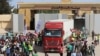 Египетские работники гуманитарных организаций приветствуют прибытие грузовика с гуманитарной помощью. Пограничный пункт Рафах, 21 октября 2023 г.