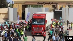 Des travailleurs humanitaires égyptiens célèbrent le retour de Gaza d'un camion en Égypte par le poste frontière de Rafah, le 21 octobre 2023.