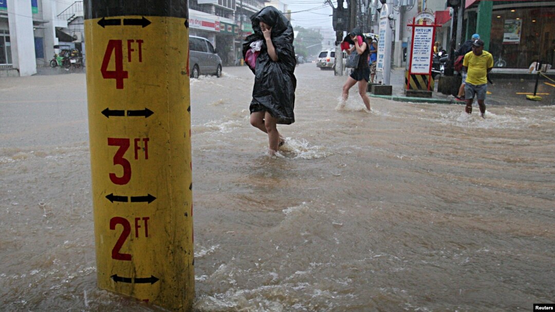 FILE - A flood warning gauge is seen along a flooded road after tropical storm Linfa hit the Philippines, July 6, 2015.