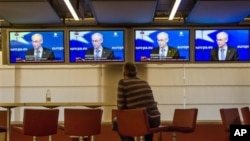 A man follows the media conference of European Council President Van Rompuy at the European Council building, Brussels, Feb. 8, 2013.