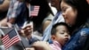 FILE - And immigrant from China holds her three-year-old son and a U.S. flag during a naturalization ceremony at the New York Public Library, in New York City, July 3, 2018. 