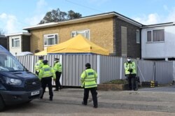 Police are seen in front of temporary barriers at a home in Deal, southeast England, on March 12, 2021, as officers continue the search for evidence in connection with the killing of Sarah Everard.