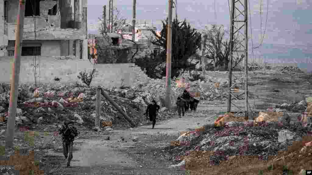 Syrian opposition fighters run for cover from government forces in Telata village, Sept. 29, 2013.