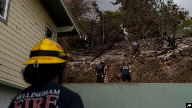 Firefighters clear debris in Kula, Hawaii, Aug. 15, 2023, following wildfires that devastated parts of the Hawaiian island of Maui.