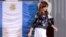 FILE - Argentina's President Cristina Fernandez walks past an Argentine flag at the Casa Rosada government palace in Buenos Aires, Argentina.