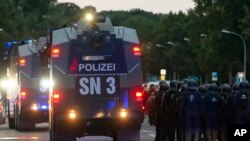 A police water cannons passes by a far-right protest in front of a Karl Marx monument in Chemnitz, Germany, Monday, Aug. 27, 2018 after a man has died and two others were injured in an altercation between several people of "various nationalities" in the eastern German city of Chemnitz on Sunday.