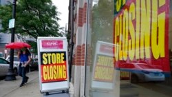 FILE - A passer-by is shown near a storefront with closing signs in Boston, Sept. 2, 2020. The U.S. unemployment rate dropped to 7.9% in September, but hiring is slowing and many Americans have given up looking for work, federal officials say.