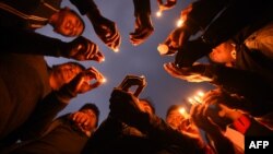 FILE - Nepali people take part in a candlelight vigil in honor of the plane crash victims in Kathmandu, March 13, 2018, a day after the deadly crash of a US-Bangla Airlines plane at the international airport. 