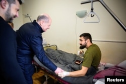 El canciller alemán Olaf Scholz y el presidente ucraniano Volodymyr Zelenskyy visitan a un soldado herido en un hospital, en medio del ataque de Rusia a Ucrania, en Kiev, Ucrania, el 2 de diciembre de 2024.