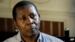 FILE - Rwandan professor Leopold Munyakazi listens to a question during an interview on Feb. 5, 2009 at his home in Towson, Md. Munyakazi, who taught French at Goucher College, was recently removed from teaching after the school became aware he was wanted in his home country on genocide charges.