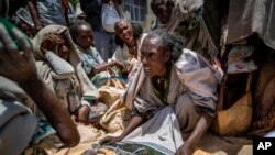 An Ethiopian woman argues with others over the allocation of yellow split peas after it was distributed by the Relief Society of Tigray in the town of Agula, in the Tigray region of northern Ethiopia, May 8, 2021.