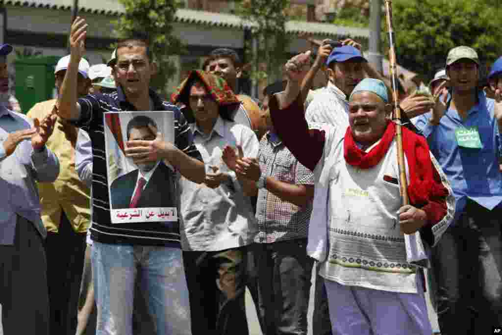 Para pendukung mantan presiden Mohamed Morsi meneriakkan slogan-slogan saat menduduki Nasser City, wilayah pinggiran kota Kairo (7/7). (AP/Paul Schemm)