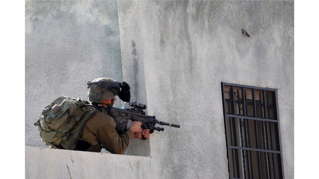 An Israeli soldier points his weapon during a Palestinian protest against Jewish settlements, in Kafr Qaddum in the Israeli-occupied West Bank, Nov. 13, 2020.