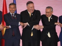 U.S. Secretary of State Mike Pompeo links hands with Singapore's Foreign Minister Vivian Balakrishnan and Thailand's Foreign Minister Don Pramudwinai at the East Asia Summit meeting in Bangkok, Aug.2, 2019.