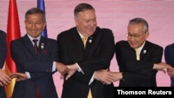 U.S. Secretary of State Mike Pompeo links hands with Singapore's Foreign Minister Vivian Balakrishnan and Thailand's Foreign Minister Don Pramudwinai at the East Asia Summit meeting in Bangkok, Aug.2, 2019. 