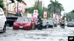 Magari yakipita kwenye barabara zilizofurika baada ya mvua kubwa kunyesha Lagos, Nigeria, Jumatano, Julai 10, 2024. (Picha za AP/Sunday Alamba).