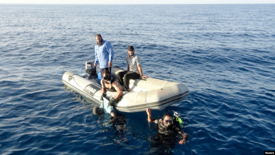 Anggota penjaga pantai Libya menemukan tubuh migran yang tenggelam di perairan Tripoli, 23 Agustus 2014.