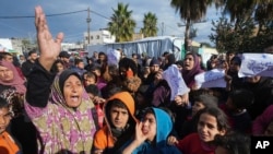 FILE - Palestinian protesters demand an end to the war with Israel and call for the release of the Israeli hostages held in the Gaza Strip by the Hamas militant group, in Deir al Balah, Gaza Strip, on January 24, 2024.