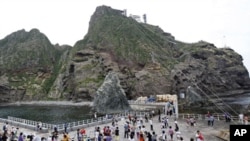 South Korean tourists are on a tour of Seodo, part of the disputed Dokdo islets, in the East Sea, August 1, 2011