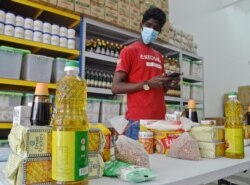 Kechara staff prepare bags of groceries to be delivered to needy families in Kuala Lumpur. (Zsombor Peter/VOA)