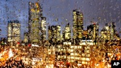 FILE - Buildings of the banking district are seen through rain drops on a glass railing in central Frankfurt, Germany, Jan. 11, 2017.