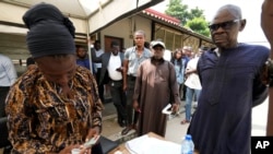 FILE: People queue to collect their elections permanent voters cards ahead of Feb. 2023 Presidential elections in Lagos, Nigeria, Wednesday, Jan. 11, 2023.
