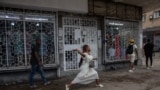 Uma jovem atira uma pedra durante confrontos entre polícia e manifestantes em Maputo, Moçambique