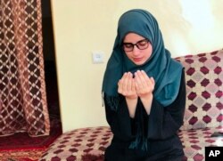 Salgy Baran prays inside her home in Kabul, Afghanistan, Aug. 26, 2021. Baran wants to stay in the country and become a doctor. But as with so many other Afghans, those plans were thrown into doubt when the Taliban rolled into Kabul this month.