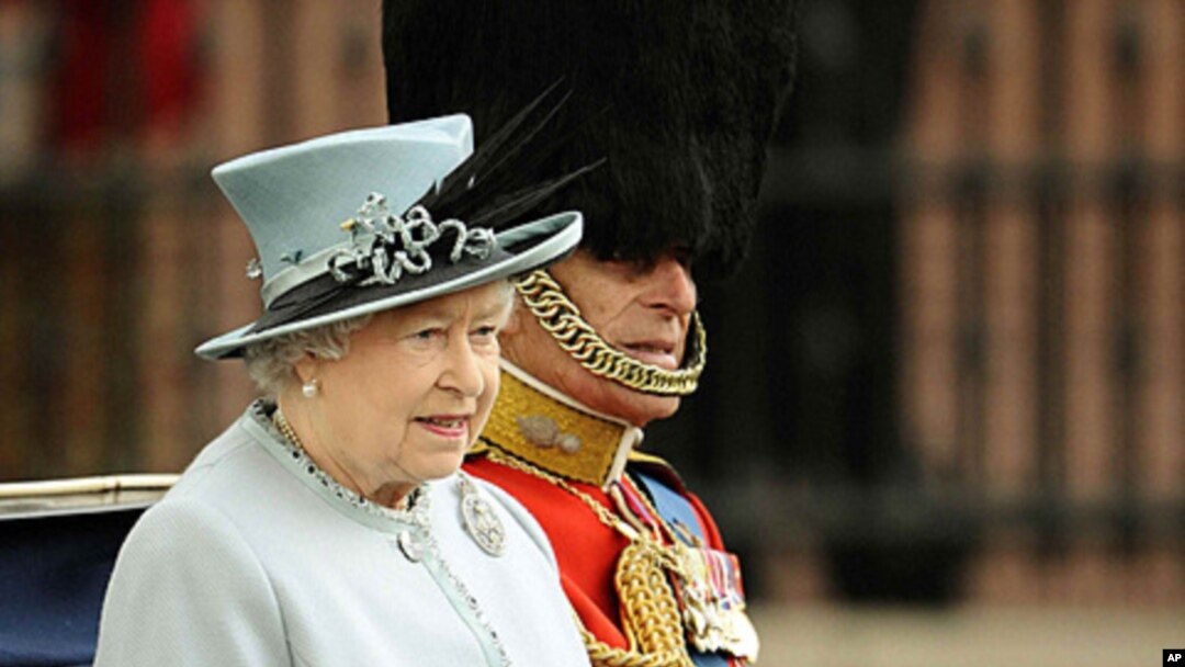 Britain's Queen Elizabeth and Prince Philip sit in a horse drawn carriage as they make their way from Buckingham Palace to attend the Trooping the Colour ceremony in central London, June 11, 2011