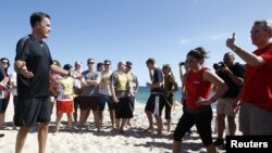 El candidato presidencial republicano y ex gobernador de Massachusetts, Romney participa en un sorteo para un partido de fútbol americano en Delray Beach, Florida.