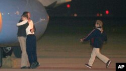 Jeffrey Fowle is greeted by his son and other family members upon his arrival at Wright-Patterson Air Force Base, Ohio, Oct. 22, 2014.