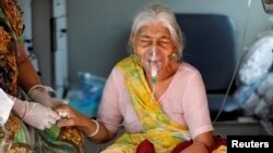 Lilaben Gautambhai Modi, 80, wearing an oxygen mask, sits inside an ambulance as she waits to enter a COVID-19 hospital for treatment, amidst the spread of the coronavirus disease (COVID-19), in Ahmedabad, India, May 5, 2021.