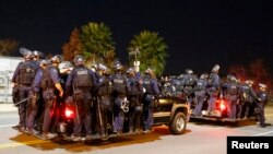Police follow protesters during a march following Monday's grand jury decision in the shooting of Michael Brown in Ferguson, Missouri, in Los Angeles, California, Nov. 25, 2014.