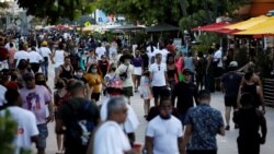 FILE - People walk along Ocean Drive during spring break festivities, amid the coronavirus outbreak, in Miami Beach, Florida, March 5, 2021.
