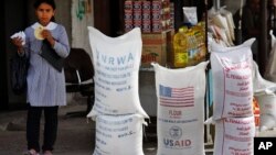 A Palestinian girl walks past sacks of flour food aid from the United Nations and USAID at the Shatie refugee camp in Gaza City. (File)