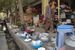 Comerciantes afganos exhiben artículos domésticos usados para vender en un área de mercado en Kabul el 25 de agosto de 2021.