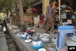 Comerciantes afganos exhiben artículos domésticos usados para vender en un área de mercado en Kabul el 25 de agosto de 2021.